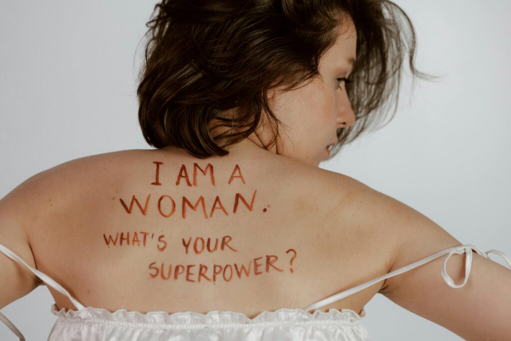 Back view of woman with empowering message, promoting self-love and feminism. Selbstfürsorge für Frauen*