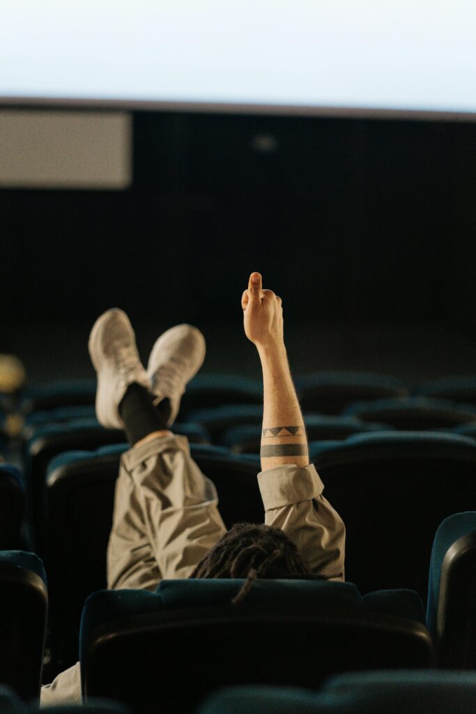 Person lounging in an empty cinema, showing a relaxed and intimate movie experience.